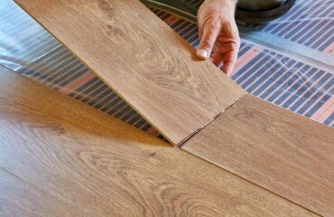 Laminate flooring. Male repairman is laying panel of laminate f Dublin laminate