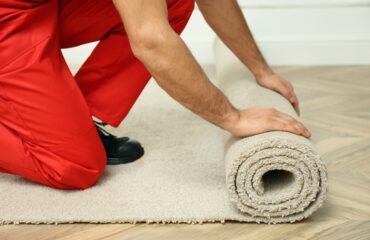 Worker Rolling Out New Carpet Flooring Indoors, Closeup carpet installation services in Dublin CA